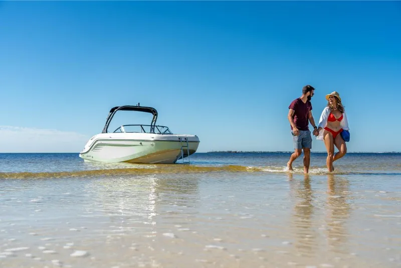 Slide: The Image of Couple enjoying beach near 2023 Bayliner DX2000 boat on a sunny day. - 24