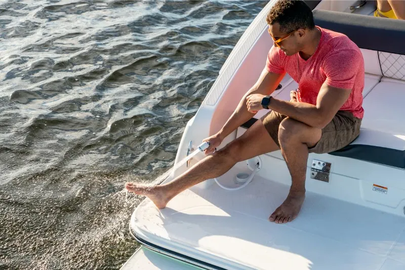Slide: The Image of Man relaxing on a 2023 Bayliner DX2050 boat, splashing water. - 28