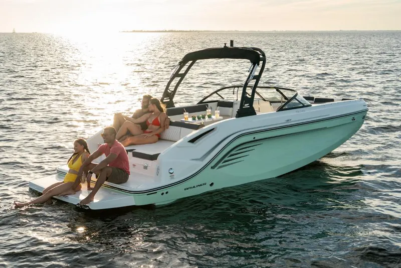 Slide: The Image of 2023 Bayliner DX2050 boat with people relaxing on the water at sunset. - 30