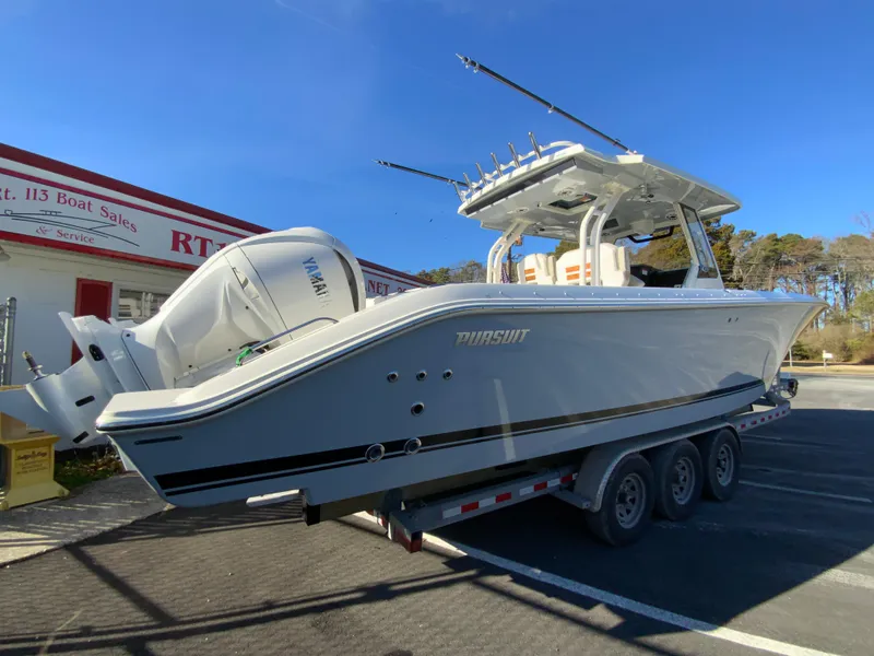 Slide: The Image of 2024 Pursuit S 328 Sport boat on a trailer at a dealership. - 12
