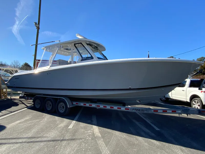 Slide: The Image of 2024 Pursuit S 328 Sport boat on a trailer under clear blue sky. - 14