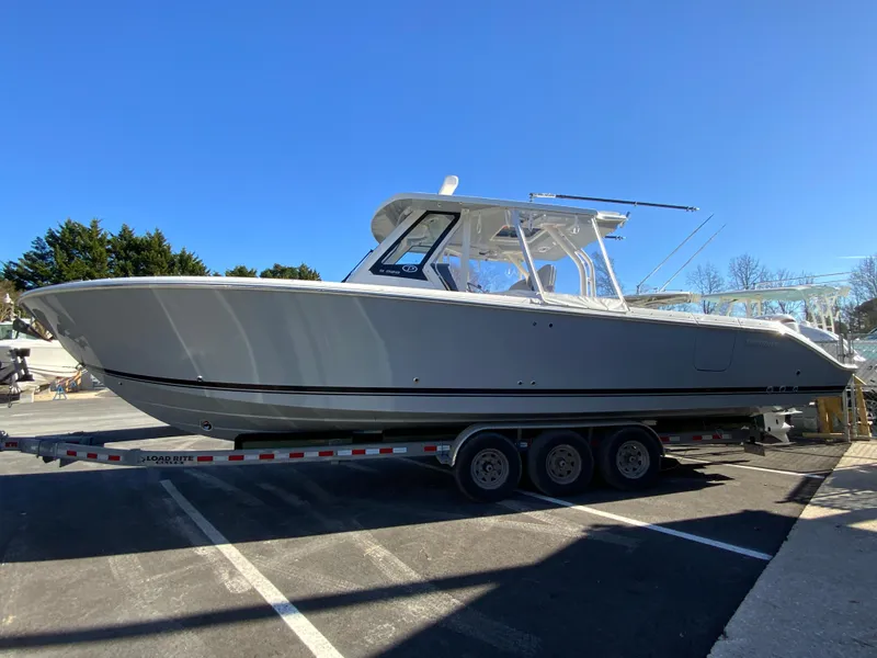 Slide: The Image of 2024 Pursuit S 328 Sport boat on a trailer in a parking lot. - 15