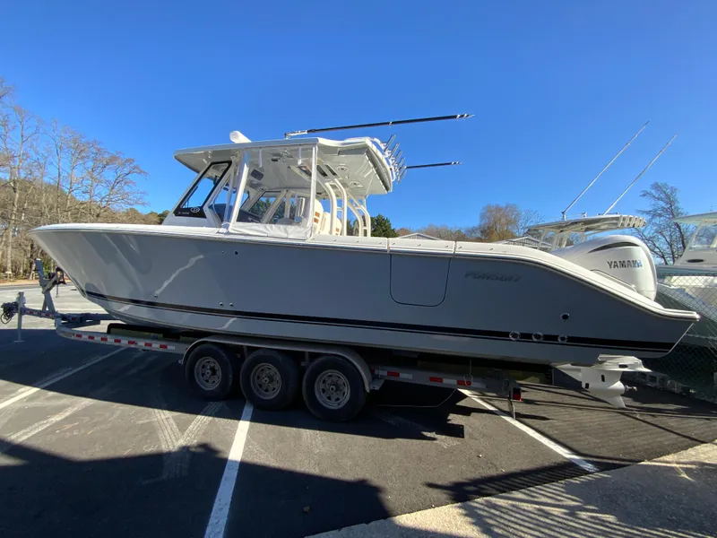 Slide: The Image of 2024 Pursuit S 328 Sport boat on a trailer in a parking lot. - 16