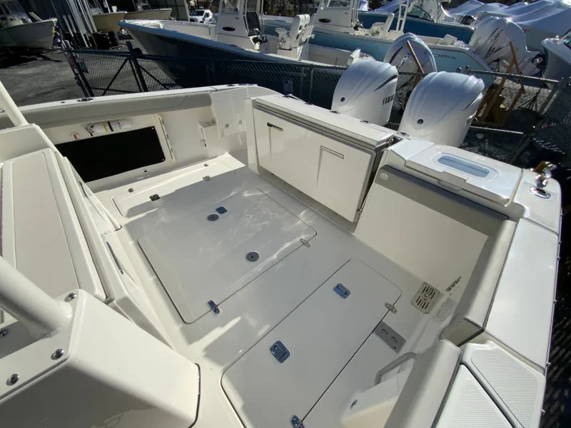 Slide: The Image of 2024 Pursuit S 328 Sport boat deck with storage compartments and seating. - 26