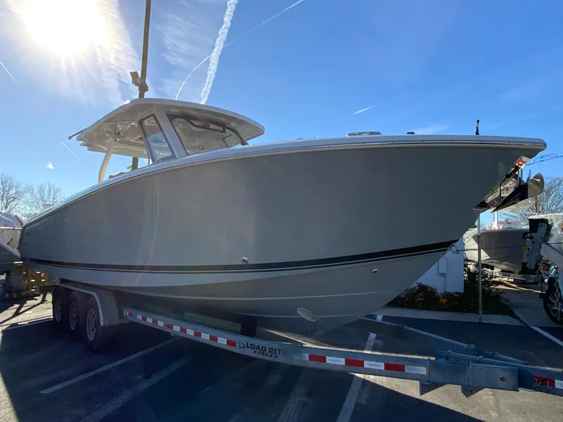Slide: The Image of 2024 Pursuit S 328 Sport boat on a trailer under a clear blue sky. - 3