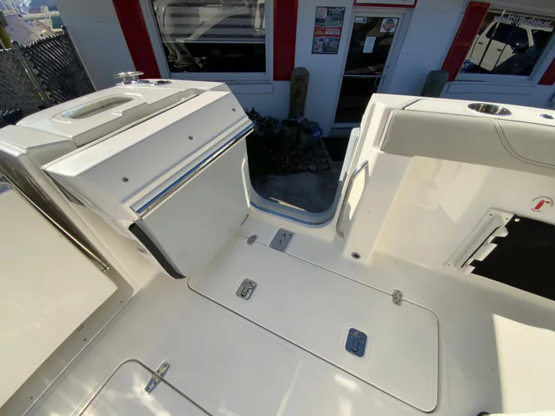 Slide: The Image of 2024 Pursuit S 328 Sport boat deck with storage compartments and access door. - 31