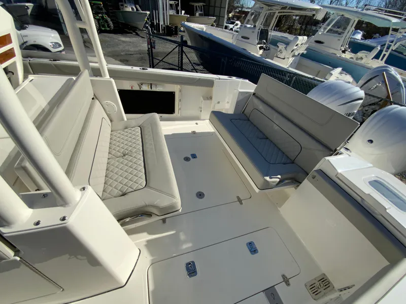Slide: The Image of 2024 Pursuit S 328 Sport boat interior with cushioned seating and storage compartments. - 35