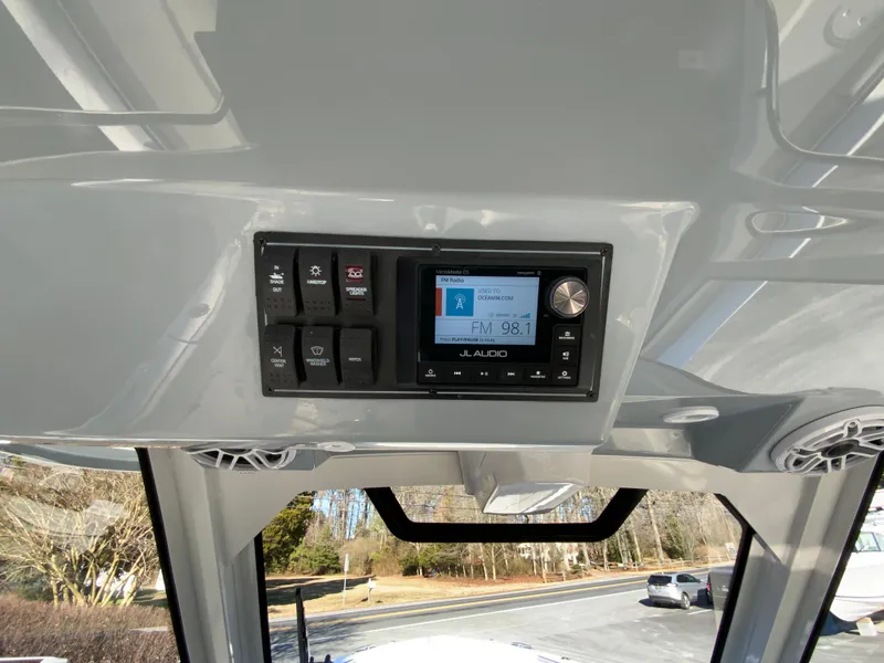 Slide: The Image of 2024 Pursuit S 328 Sport boat dashboard with JL Audio system and control switches. - 44