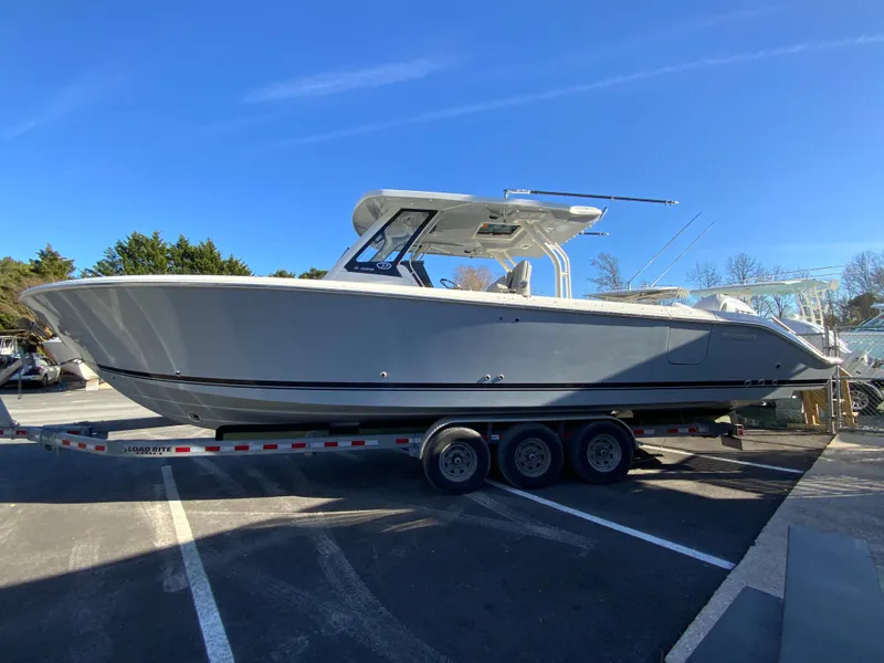 Slide: The Image of 2024 Pursuit S 328 Sport boat on a trailer in a parking lot. - 8