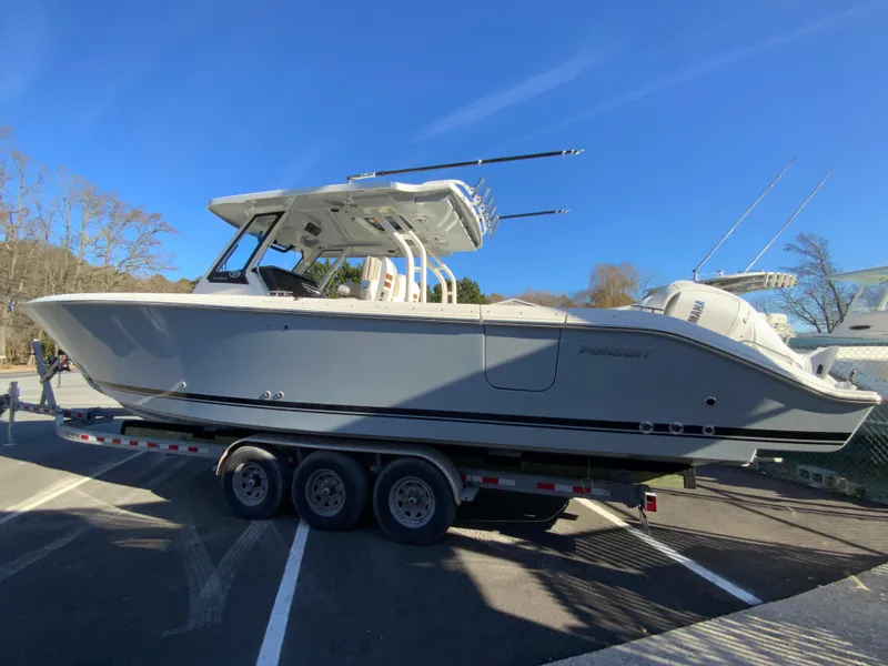 Slide: The Image of 2024 Pursuit S 328 Sport boat on a trailer in a parking lot. - 9