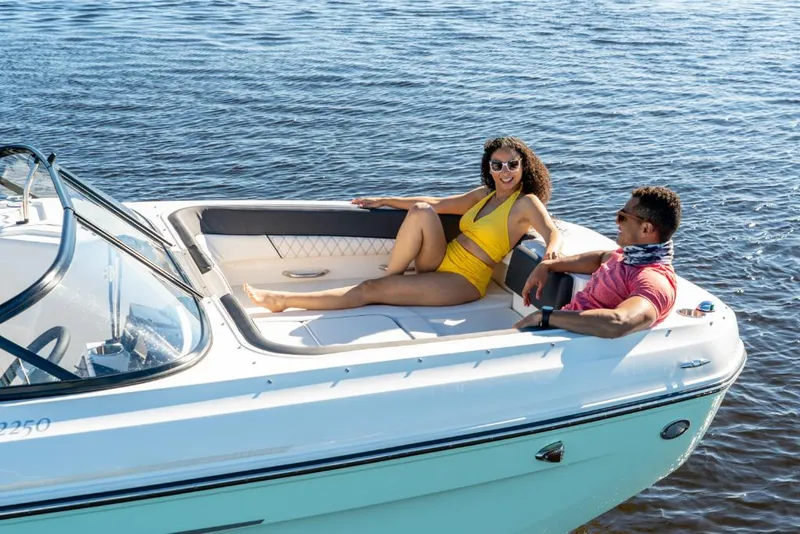 Slide: The Image of 2023 Bayliner DX2200 boat with two people relaxing on deck. - 15