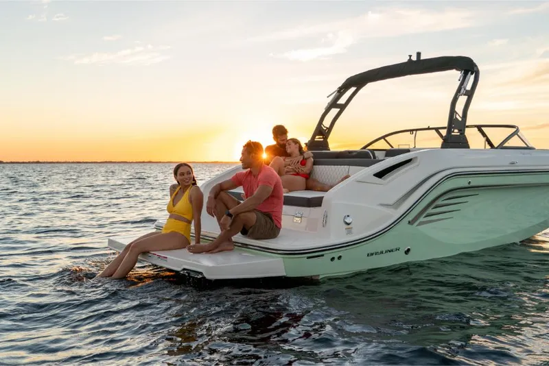 Slide: The Image of 2023 Bayliner DX2200 boat with people enjoying sunset on the water. - 35