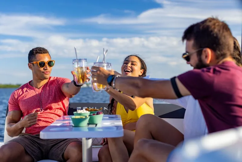 Slide: The Image of Friends enjoying drinks on a 2023 Bayliner DX2200 boat. - 49