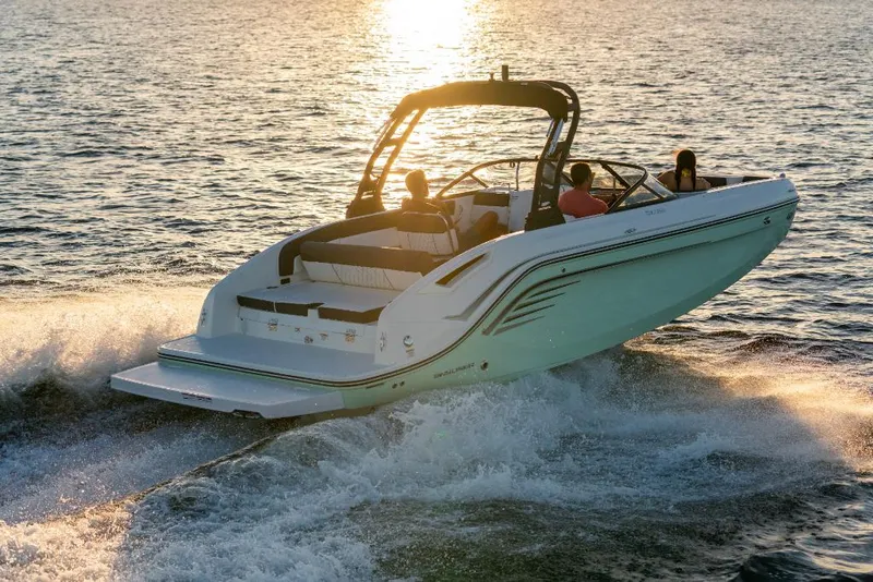 Slide: The Image of 2023 Bayliner DX2250 boat cruising on water at sunset. - 10