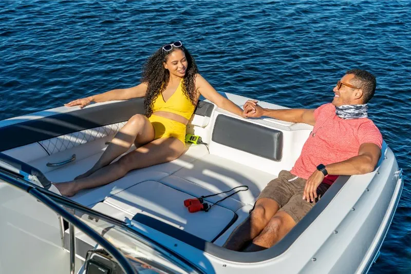 Slide: The Image of Couple relaxing on a 2023 Bayliner DX2250 boat in sunny weather. - 16