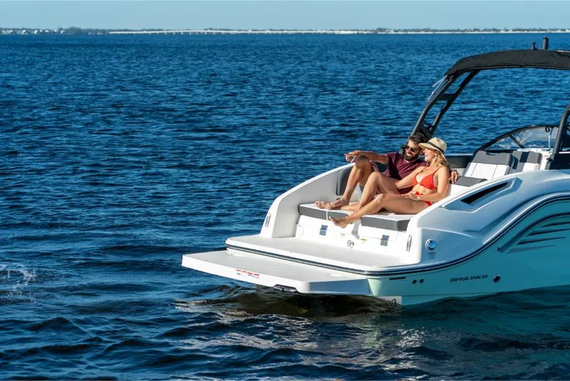 Slide: The Image of 2023 Bayliner DX2250 boat with people relaxing on the deck in open water. - 18
