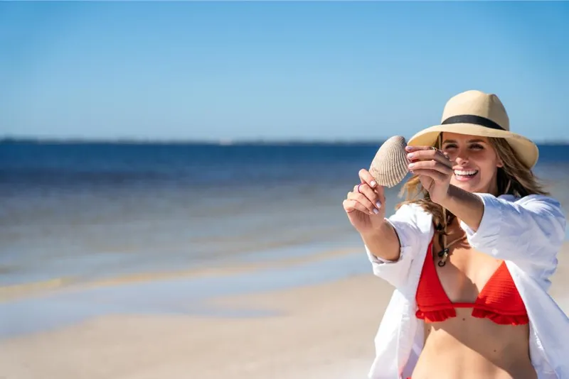 Slide: The Image of Woman enjoying the beach, holding a seashell, Bayliner DX2250, 2023. - 25