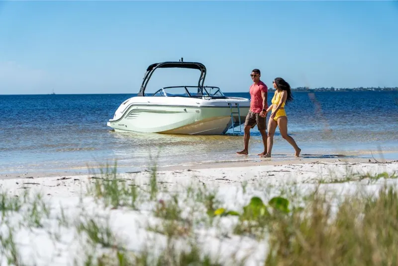 Slide: The Image of Couple walking on beach near 2023 Bayliner DX2250 boat. - 27