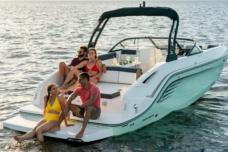 Slide: The Image of 2023 Bayliner DX2250 boat with people relaxing on the deck in the water. - 31