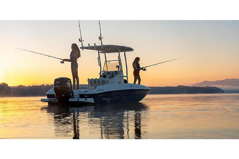 Slide: The Image of 2023 Bayliner T18 boat with two people fishing at sunrise on calm water. - 6