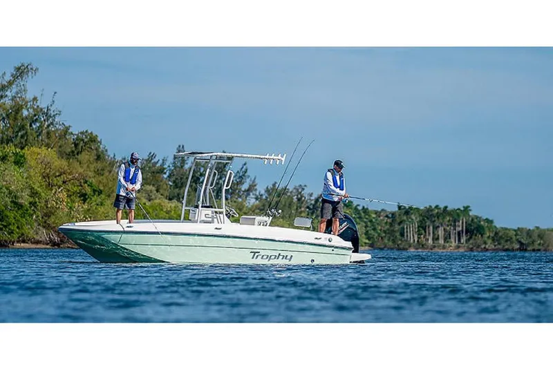 Slide: The Image of 2023 Bayliner T21 boat with two people fishing on a calm lake. - 2