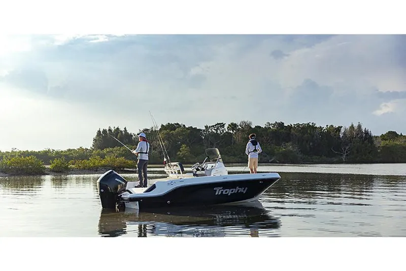 Slide: The Image of 2023 Bayliner T20 CC boat on calm water with two people fishing. - 2