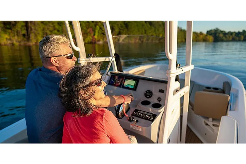 Slide: The Image of Couple enjoying a ride on a 2023 Bayliner T20 CX boat on a sunny day. - 7