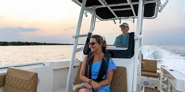 Slide: The Image of 2023 Bayliner T22 CX boat cruising at sunset with passengers. - 4