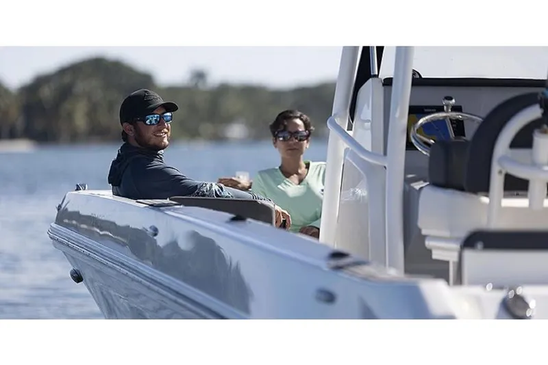 Slide: The Image of 2023 Bayliner T24 CC boat with two people enjoying a sunny day on the water. - 10