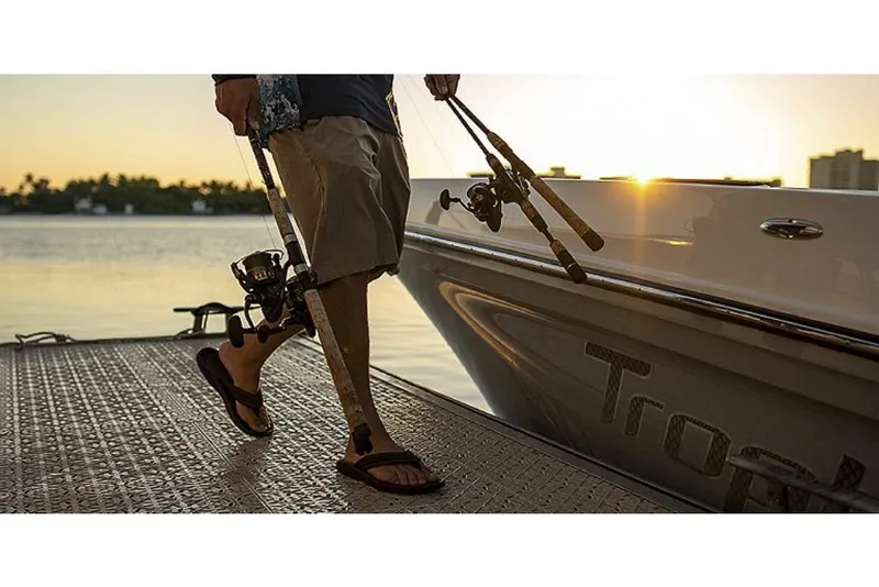 Slide: The Image of Man with fishing rods boarding 2023 Bayliner T24 CC boat at sunset. - 6