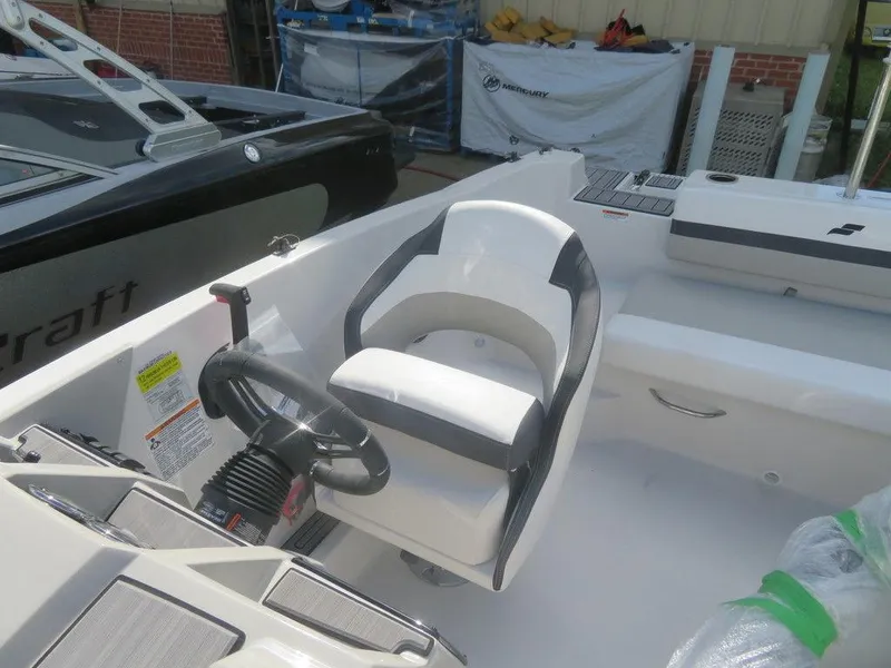Slide: The Image of 2023 Starcraft SVX 191 OB boat interior with steering wheel and captain's chair. - 10