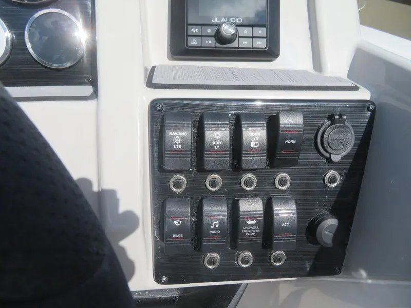 Slide: The Image of Control panel of 2023 Starcraft SVX 191 OB boat with various switches and a JL Audio system. - 14