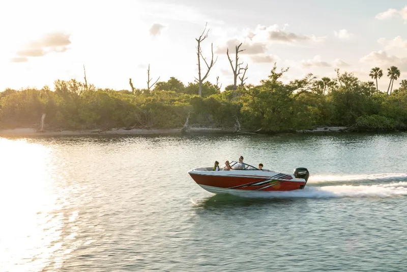 Slide: The Image of 2023 Bayliner VR4 Bowrider speeding on a serene lake at sunset. - 14