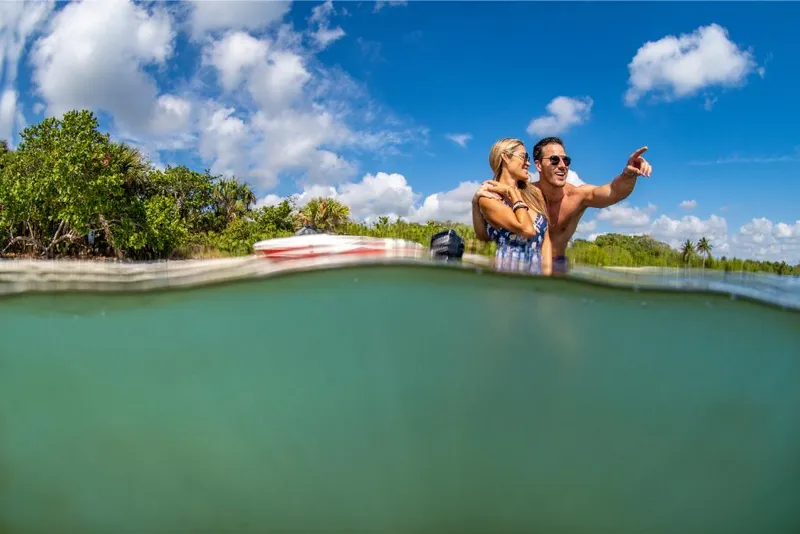 Slide: The Image of Couple enjoying water near 2023 Bayliner VR4 Bowrider boat on a sunny day. - 23