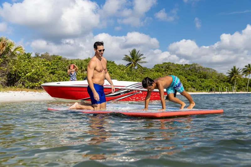 Slide: The Image of Family enjoying water activities near 2023 Bayliner VR4 Bowrider boat on a sunny beach. - 30