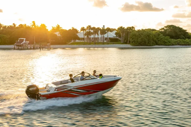 Slide: The Image of 2023 Bayliner VR4 Outboard boat cruising on a serene lake at sunset. - 1