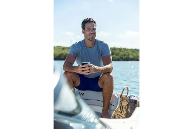 Slide: The Image of Man relaxing on a 2023 Bayliner VR4 Outboard boat, enjoying a sunny day on the water. - 34