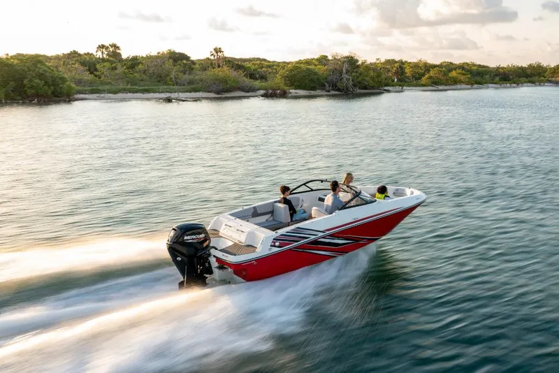 Slide: The Image of 2023 Bayliner VR4 Outboard speeding on water near lush shoreline. - 7