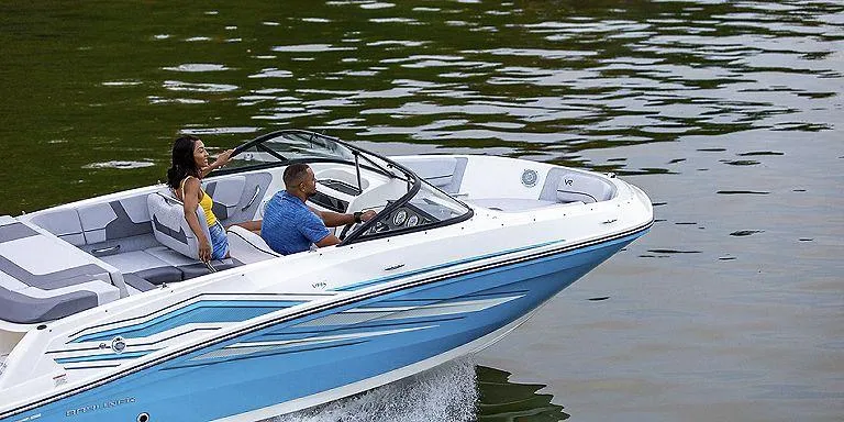 Slide: The Image of 2023 Bayliner VR5 Outboard boat cruising on water with two passengers. - 8