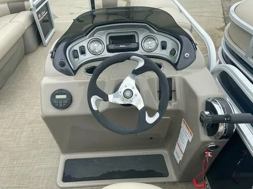 Slide: The Image of 2021 Sun Tracker Party Barge 22 DLX steering console with gauges and controls. - 11