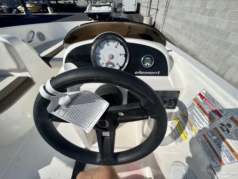 Slide: The Image of 2023 Bayliner E18 boat dashboard with steering wheel and gauges. - 6