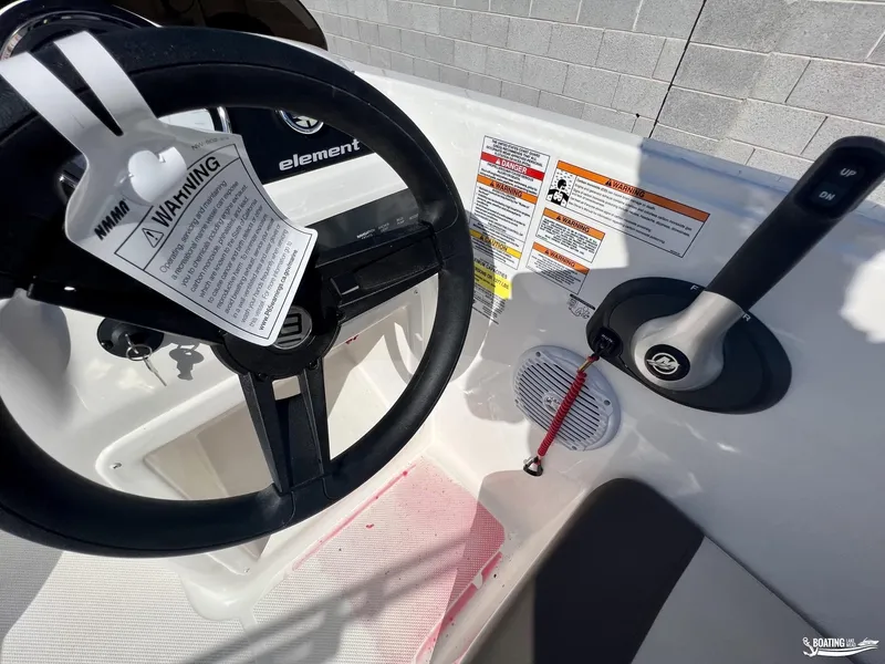 Slide: The Image of 2023 Bayliner E18 boat dashboard with steering wheel and control panel. - 7