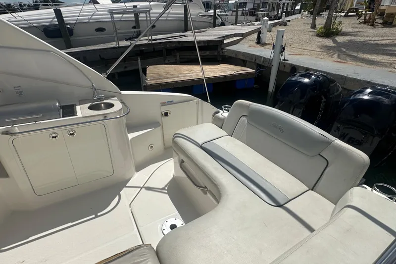 Slide: The Image of 2011 Sea Ray Sundancer 280 interior with seating and kitchenette, docked at marina. - 34