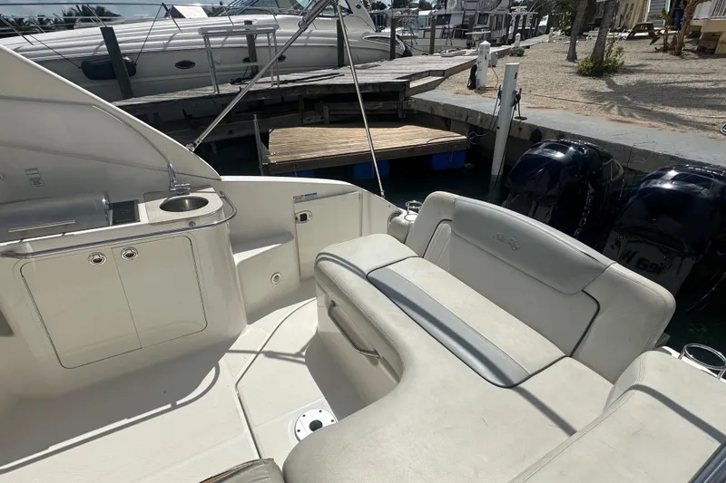 Slide: The Image of 2011 Sea Ray Sundancer 280 interior with seating and kitchenette, docked at marina. - 35