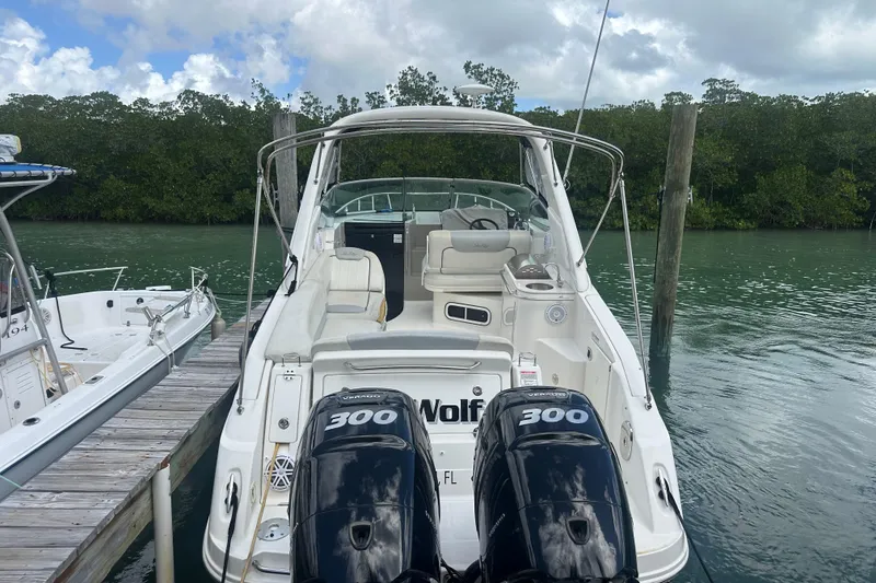 Slide: The Image of 2011 Sea Ray Sundancer 280 docked, featuring twin 300 horsepower engines, in a serene marina setting. - 54