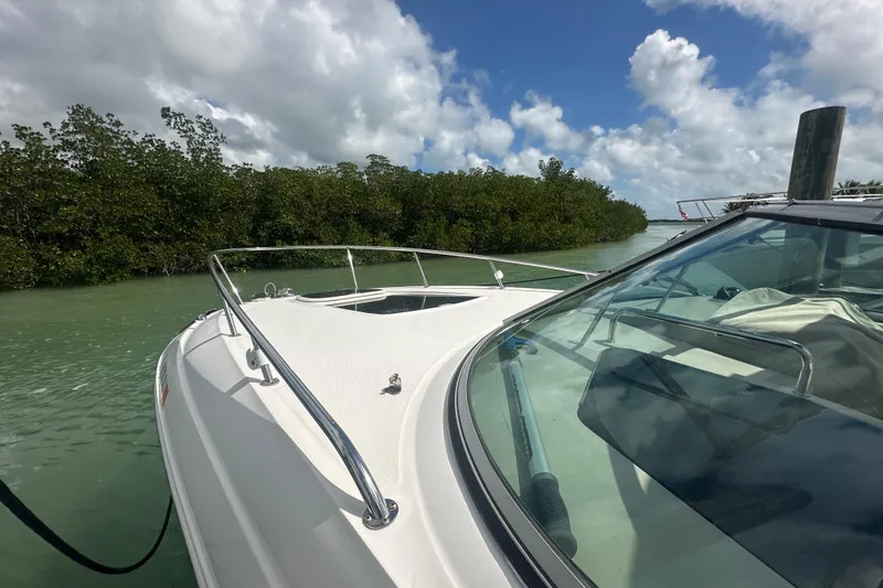 Slide: The Image of 2011 Sea Ray Sundancer 280 cruising in a serene, mangrove-lined waterway under a partly cloudy sky. - 9