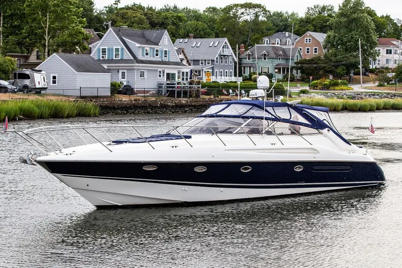 Slide: The Image of 1999 Sunseeker Camargue yacht with $250k in upgrades, docked near waterfront homes. - 2