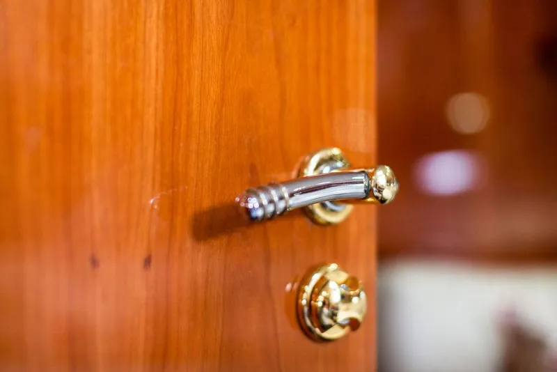 Slide: The Image of Close-up of a polished wooden door with a brass handle on a 1999 Sunseeker Camargue yacht. - 27