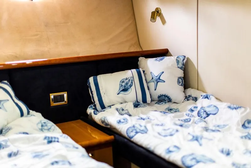 Slide: The Image of Twin beds in the 1999 Sunseeker Camargue yacht cabin with nautical-themed bedding. - 29