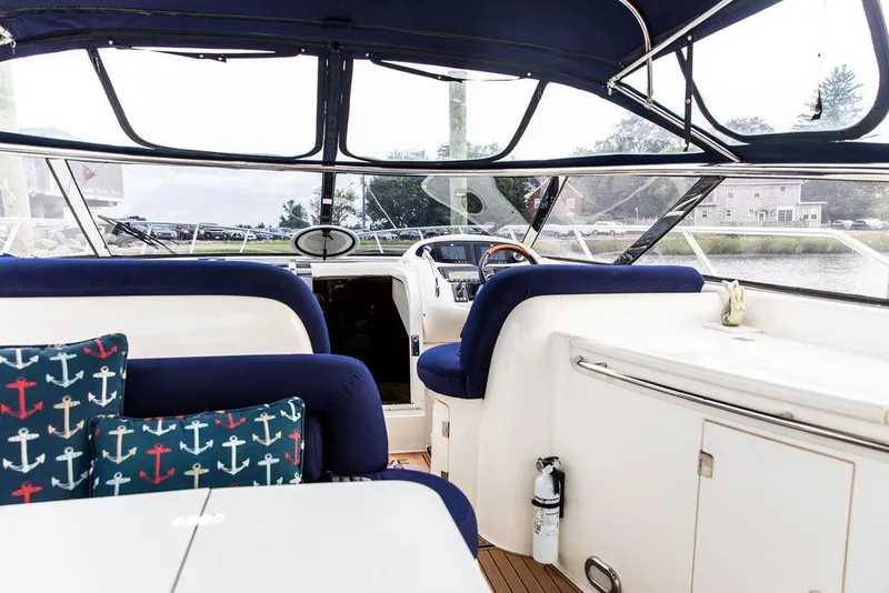 Slide: The Image of Interior of 1999 Sunseeker Camargue yacht with $250k in upgrades, featuring blue seating and nautical decor. - 43